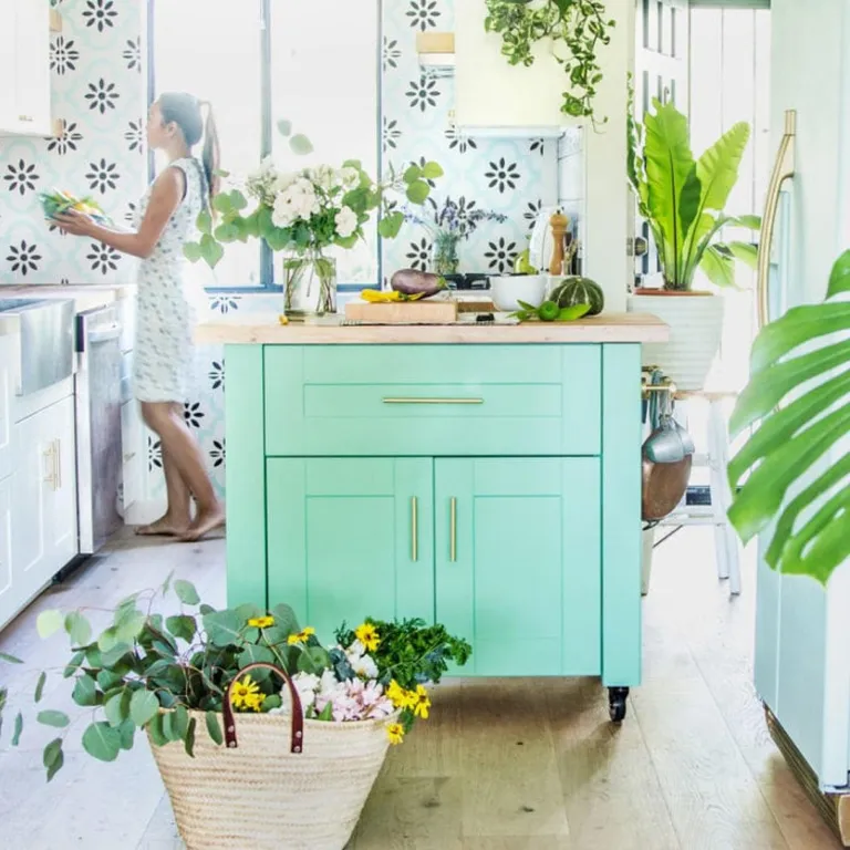 Îlot central style campagne chic, avec meuble bas IKEA peint en vert menthe, plan de travail en érable et roulettes, parfait pour petite cuisine chaleureuse