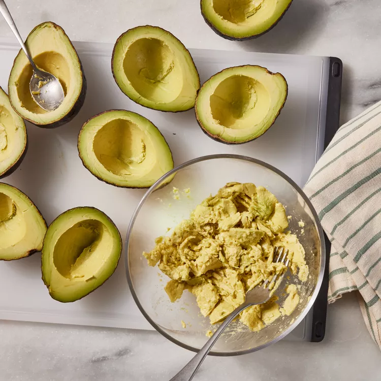 Demi-avocats farcis au saumon, servis frais avec citron et herbes aromatiques etape2
